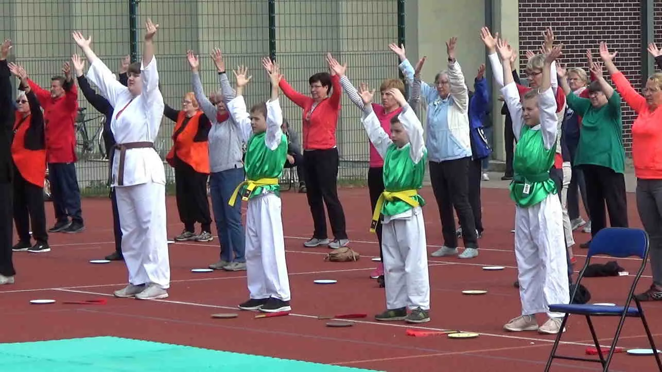 Mehrere Generationen bei einer gemeinsamen Qi-Gong-Übung im Freien