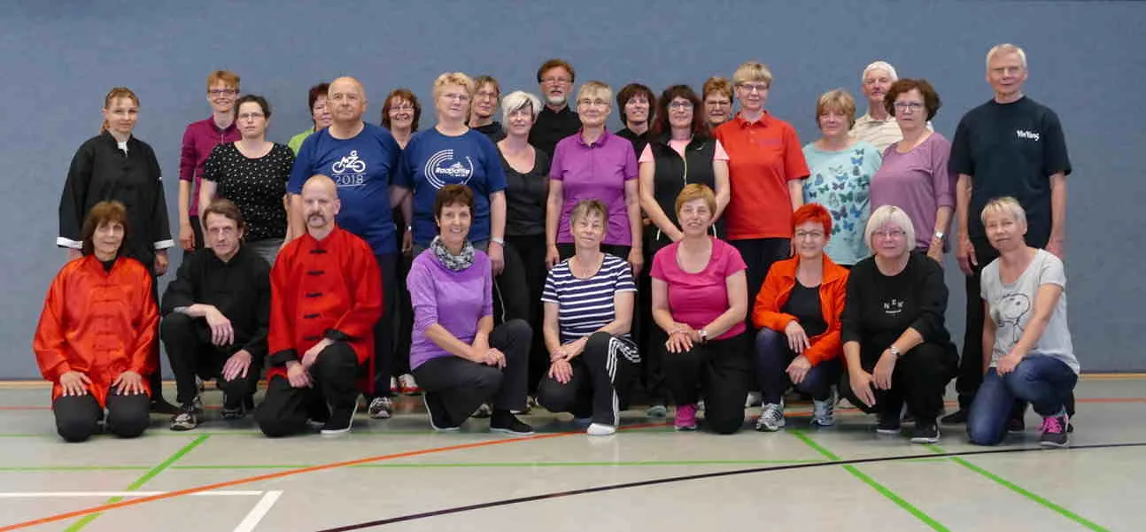 Große Vereinsgruppe bei einer gemeinsamen Veranstaltung in einer Sporthalle